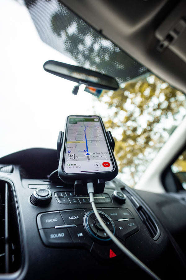 Smartphone held in a wireless charging car mount on the dashboard
